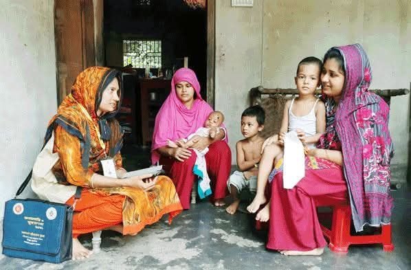 একজন তথ্য সংগ্রহকারী নারী একটি পরিবারের সদস্যদের কাছ থেকে তথ্য নিচ্ছেন, পাশে মা, শিশু ও কিশোররা বসে আছে। নিচে সবুজ ব্যানারে লেখা — “জাতীয় খানা জরিপ শুমারি ২০২৫: তথ্য সংগ্রহকারি বিশাল নিয়োগ, ৪৫ দিনে ভাতা ১ লাখ ১৭ হাজার।”